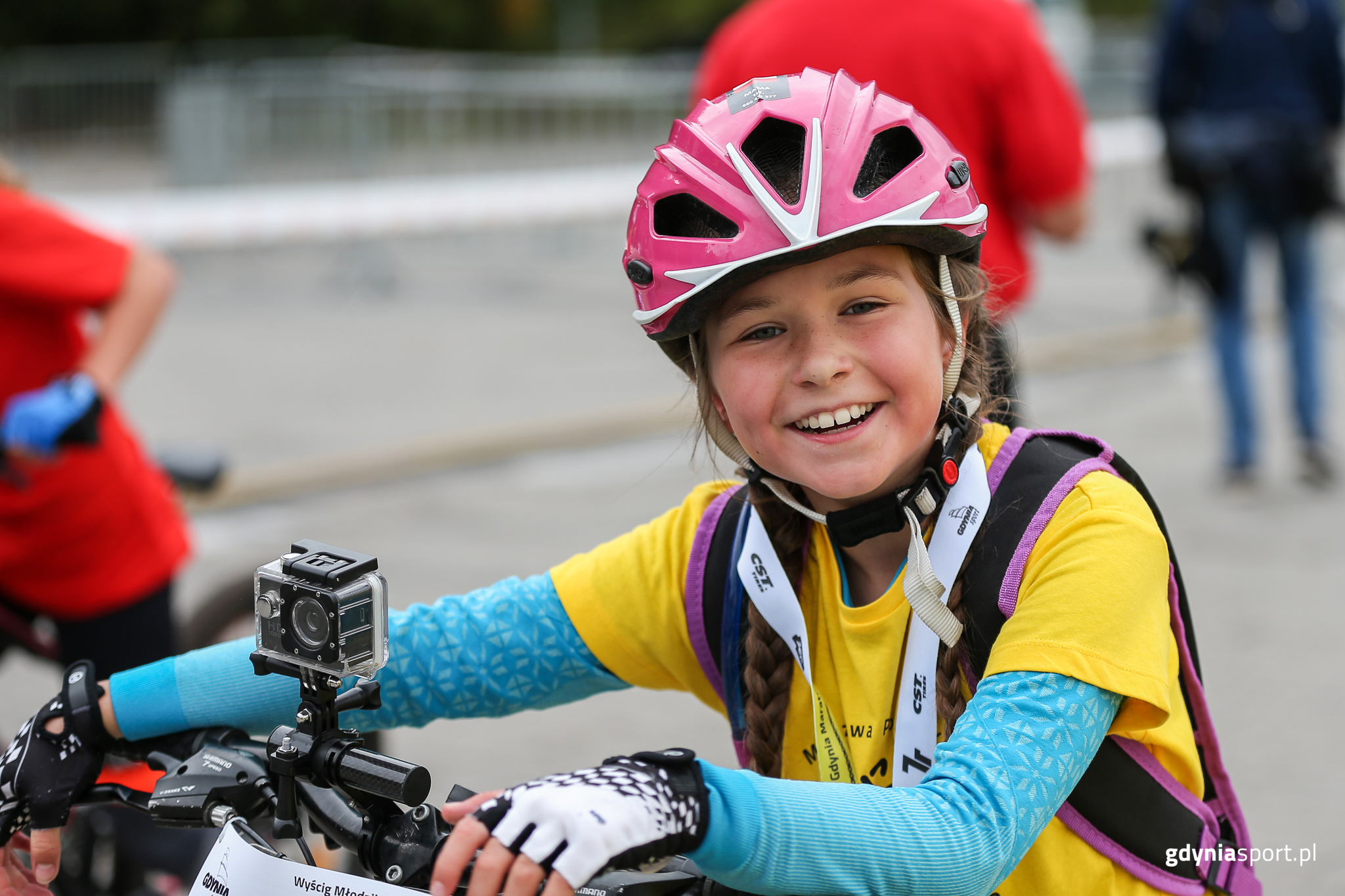 młoda uśmiechnięta zawodniczka prowadząca rower