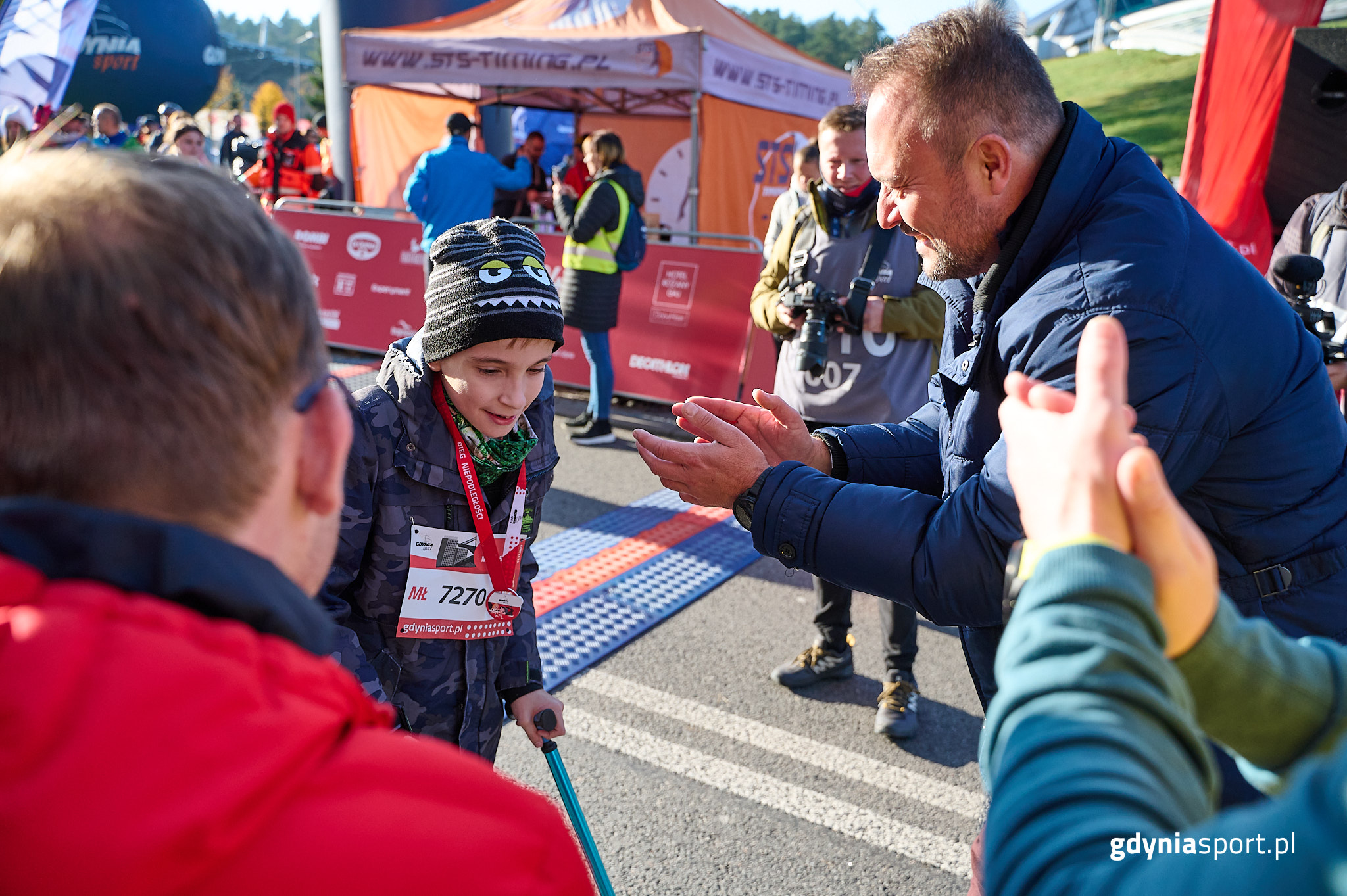 Janek odbierający na mecie medal od wiceprezydenta 