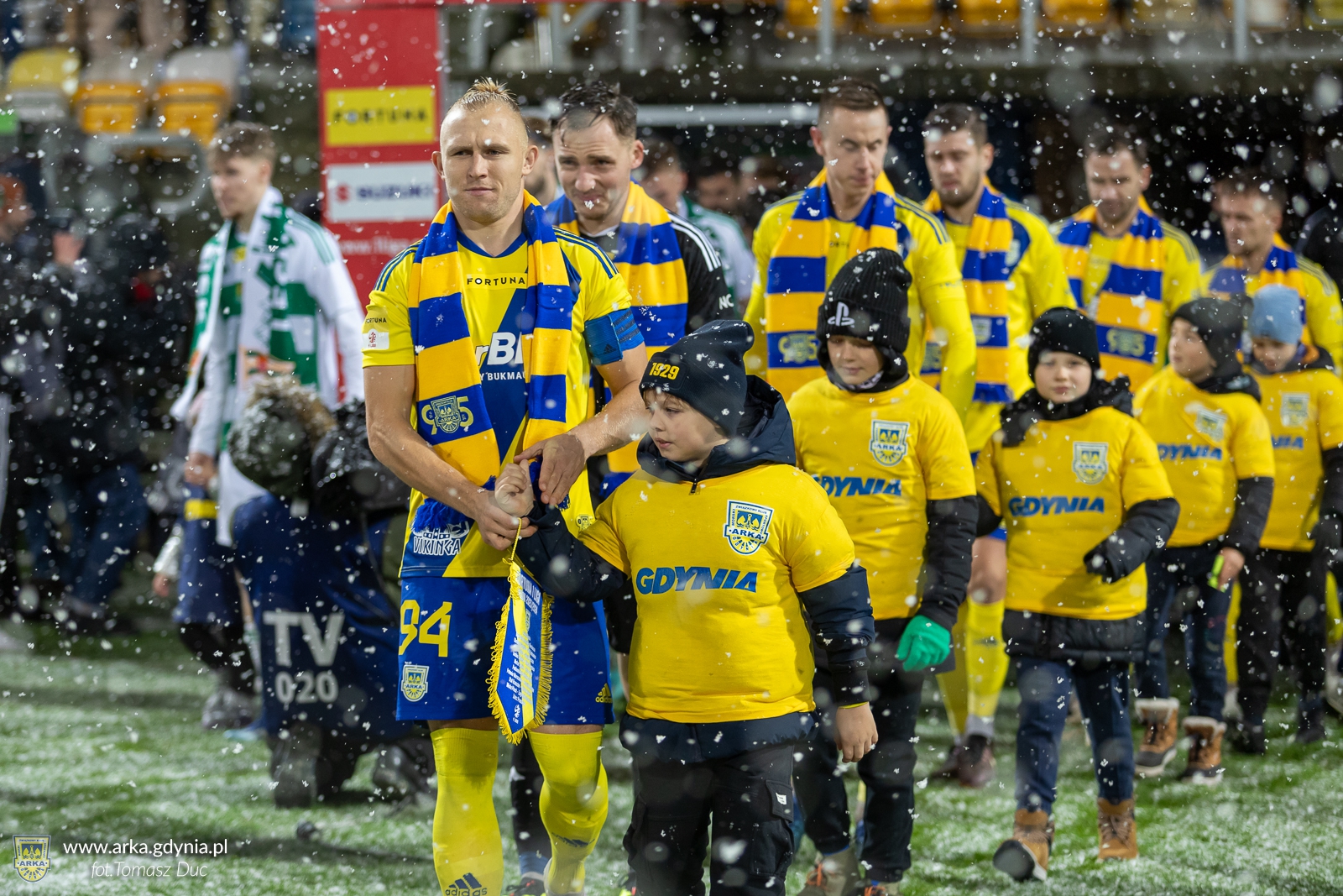 Dawid Gojny wyprowadzający piłkarzy Arki na mecz