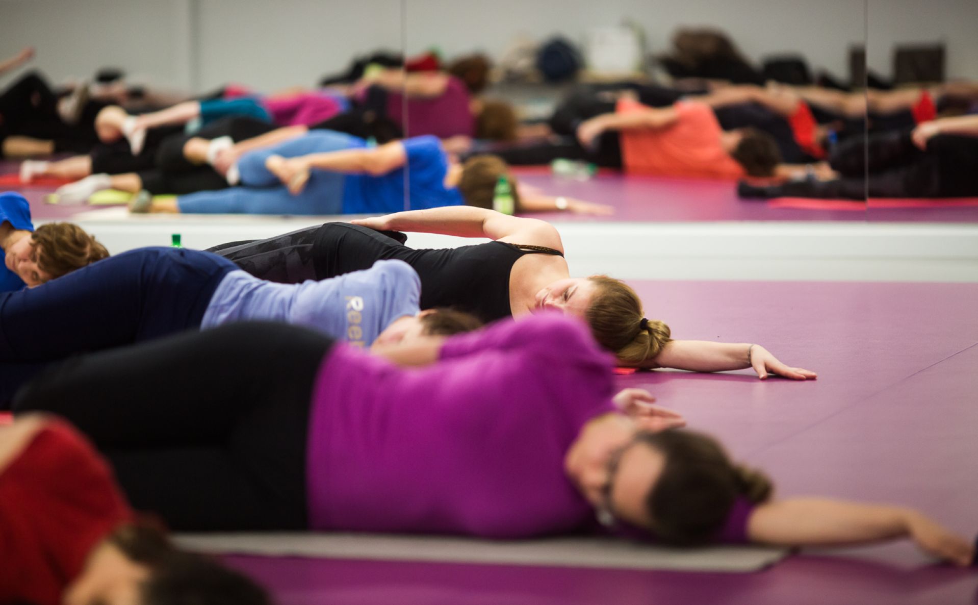 Osoby ćwiczące pilates na hali