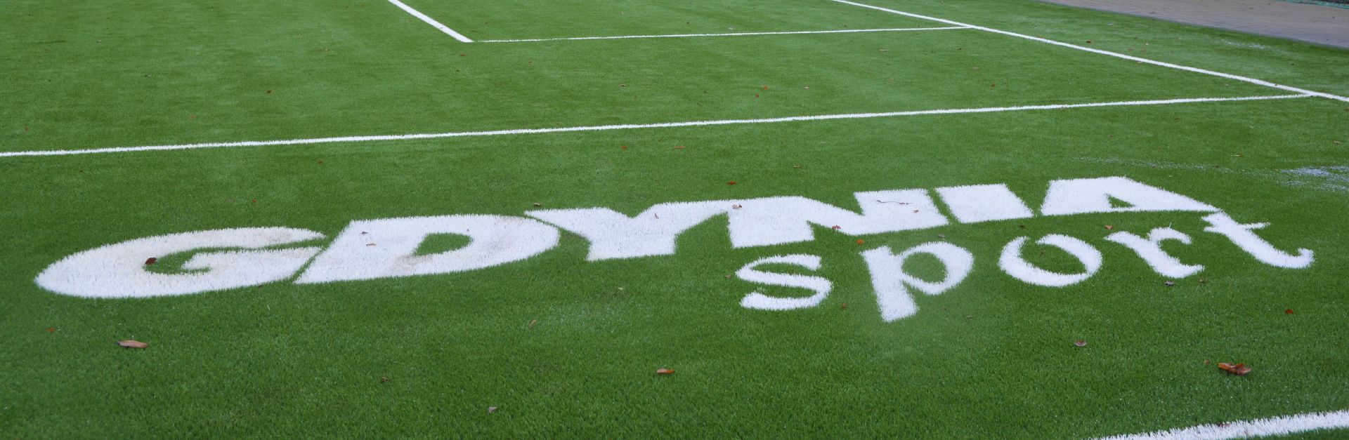 napis "Gdynia Sport" na trawie 