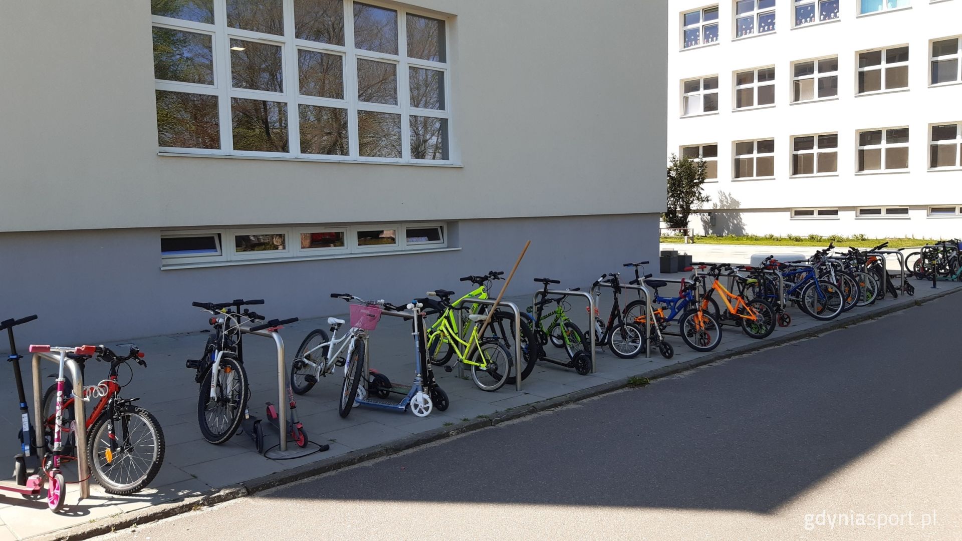 Rowerki i hulajnogi zaparkowane pod szkołą 