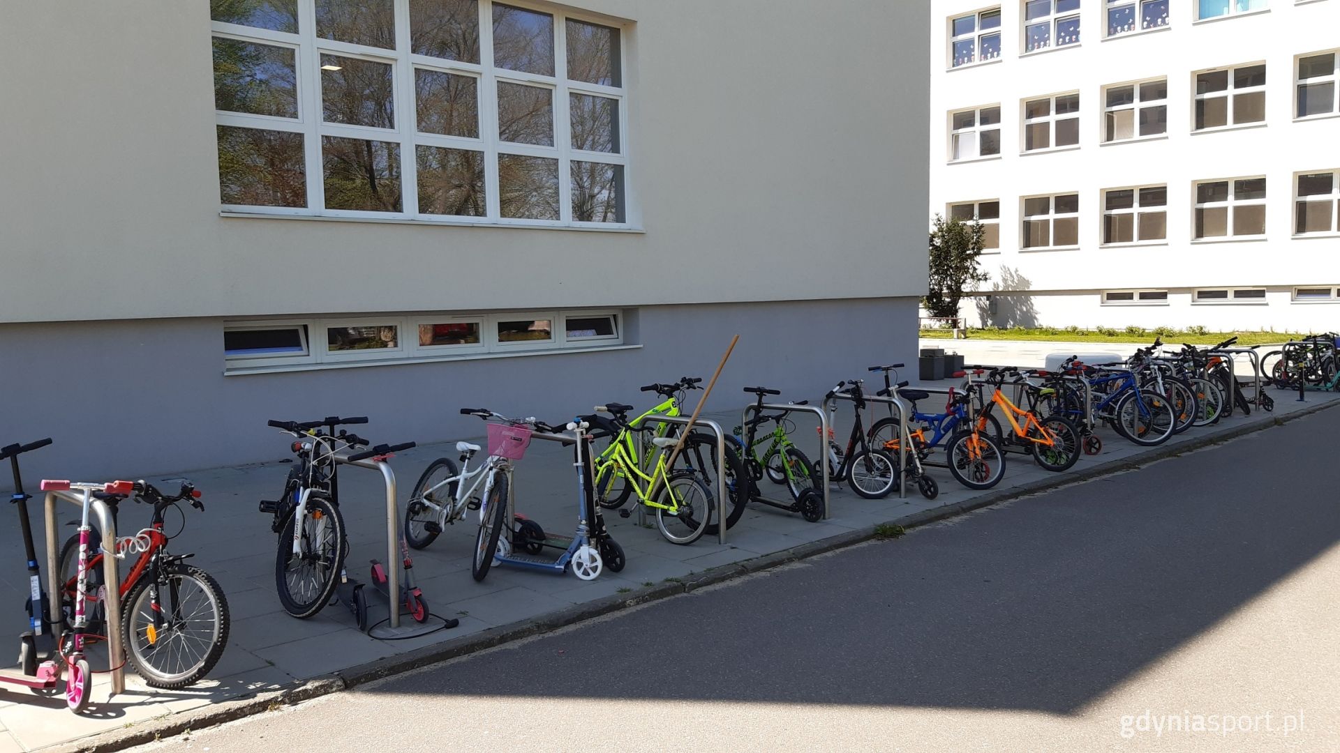 Rowerki i hulajnogi zaparkowane pod szkołą