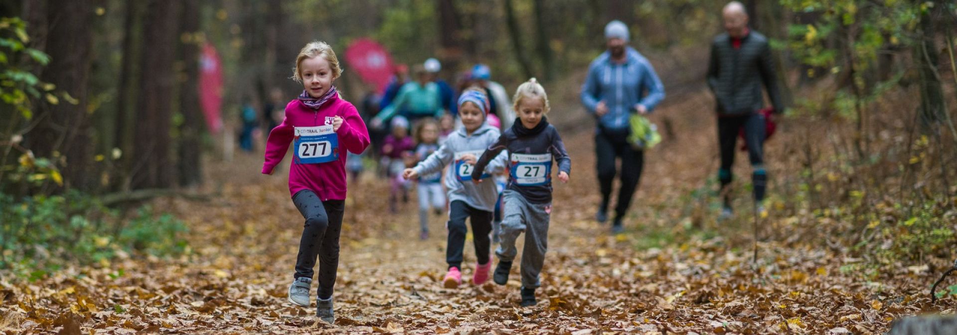 Dzieci biegnące w lesie