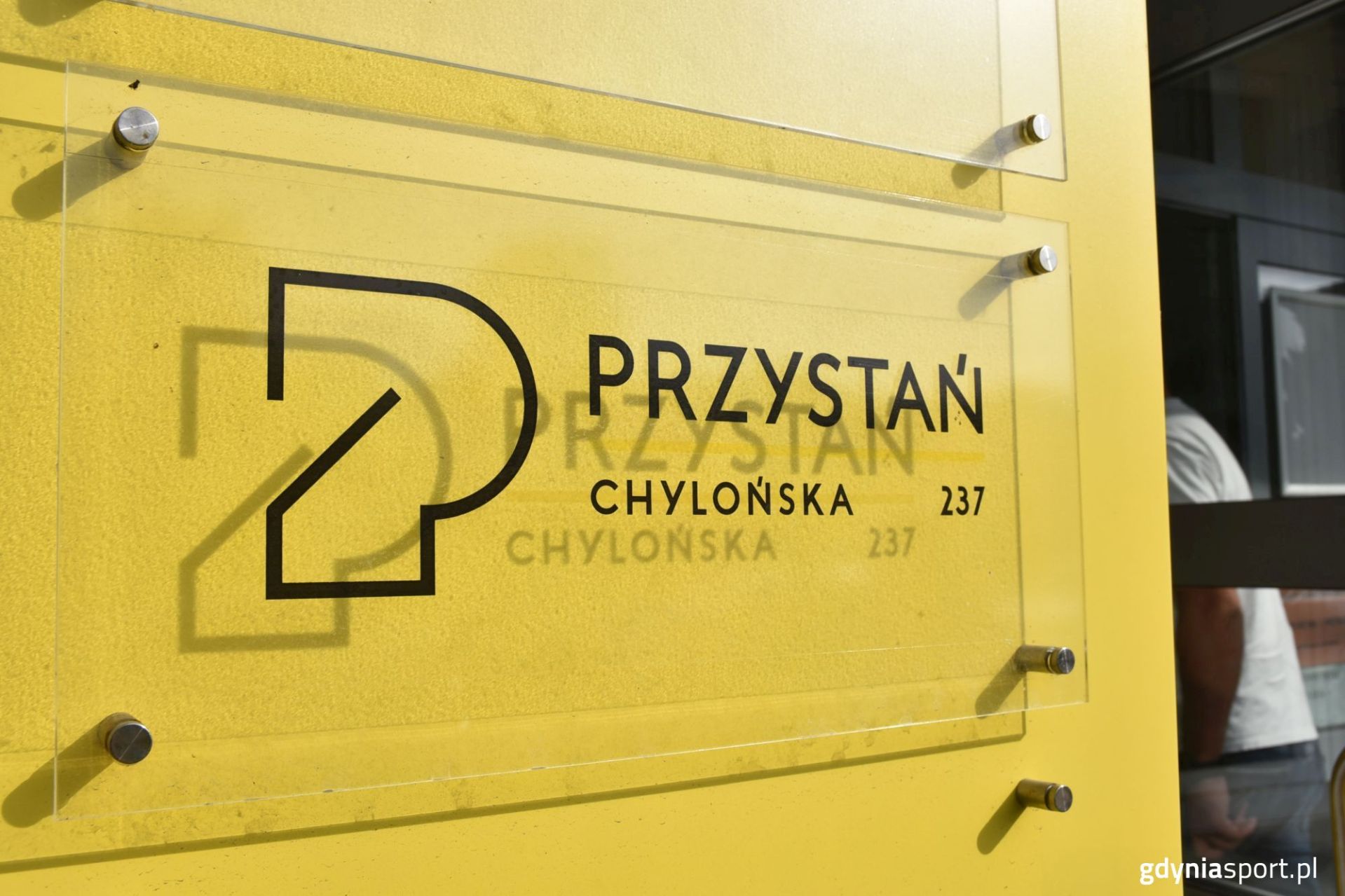 szyld przystani na żółtej ścianie