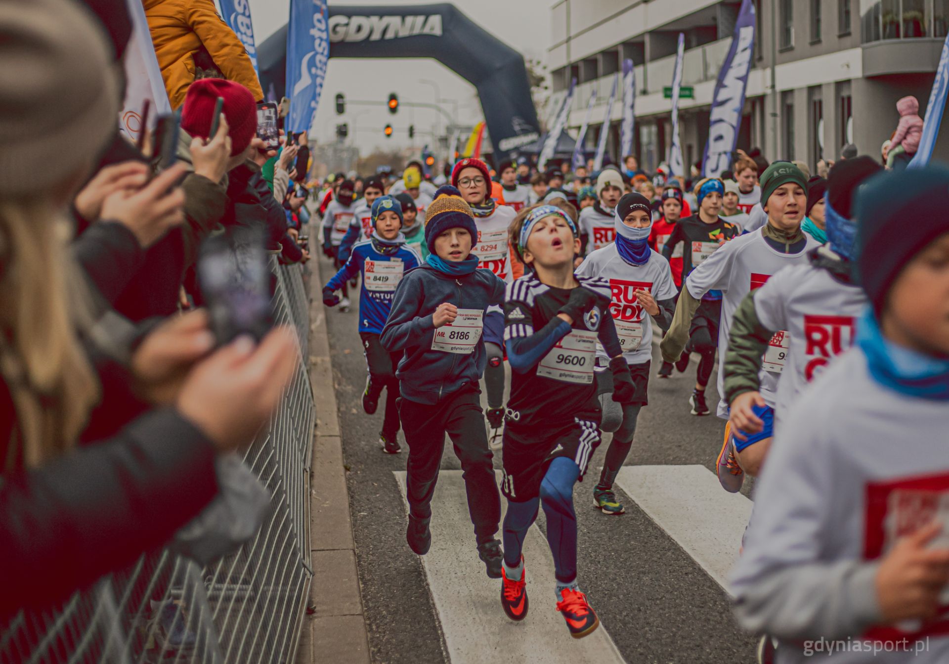 Biegnące dzieci po ulicy Gdyni